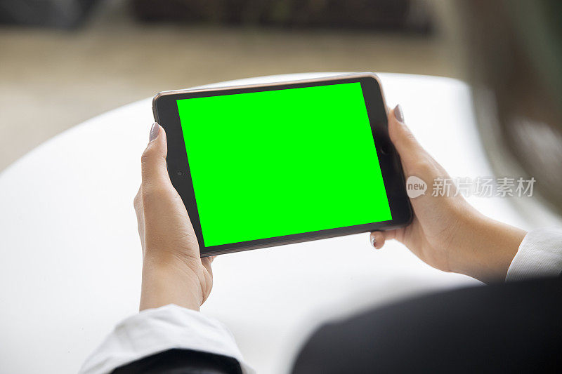 手持数码平板电脑的女商人。绿色屏幕可用于复制。它可以应用于许多领域，如通信，金融，股票市场。可以实现技术突破。色度键。