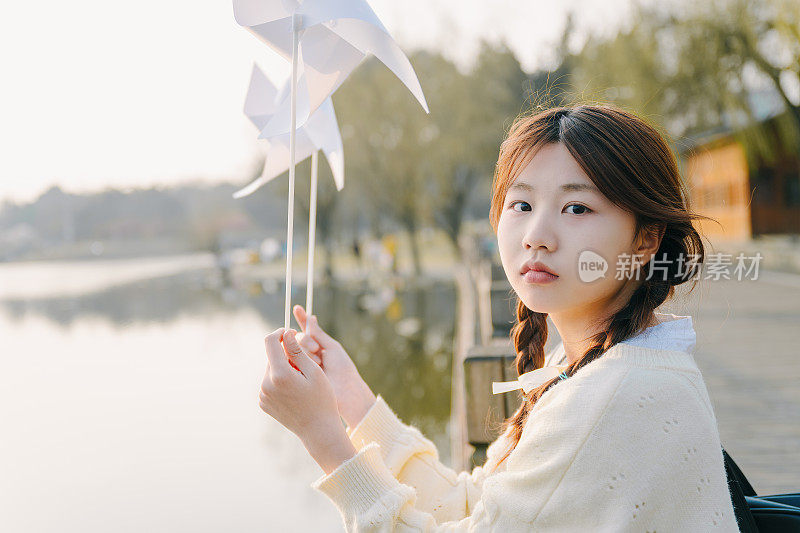 一个美丽的亚洲女孩在黄昏湖边