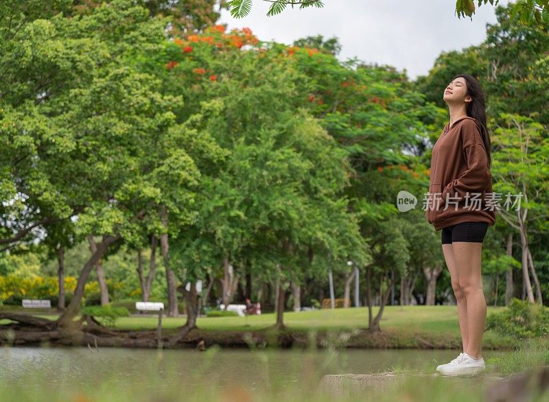 年轻的亚洲女性在公园里享受清风