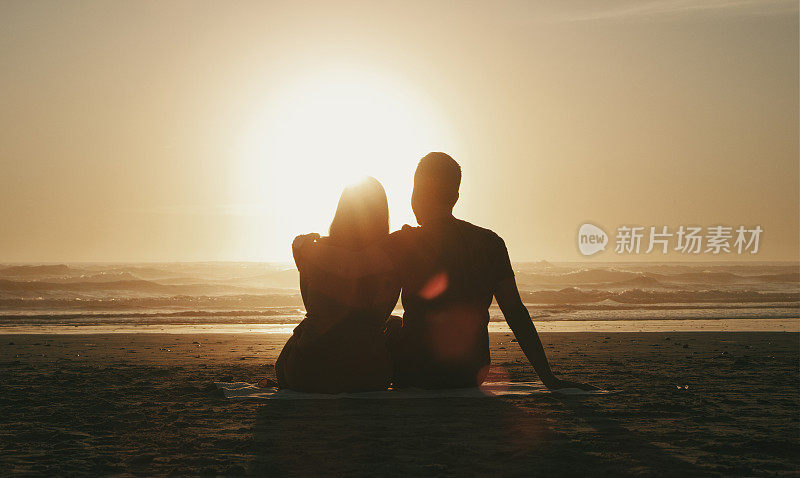 爱，日落和情侣在海滩度假一起浪漫，放松或暑假事件。海边，日出的时候，男人和女人看着海浪，在黄昏的时候拥抱或拥抱