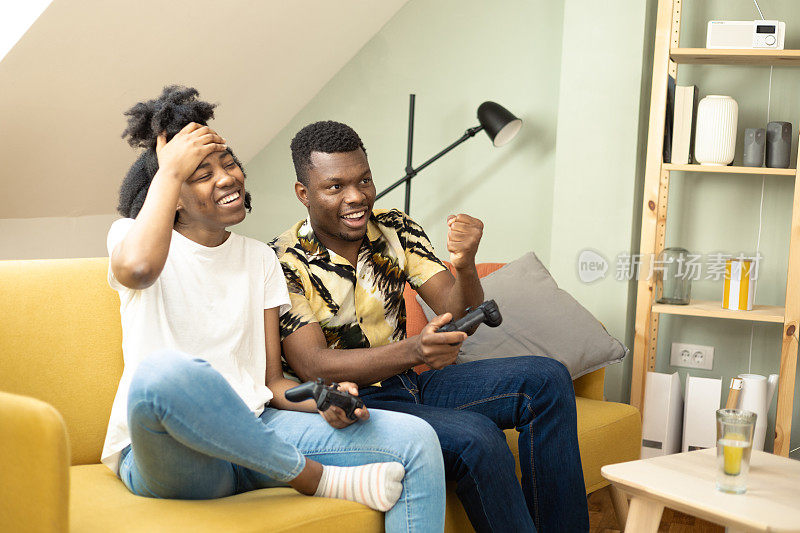 非裔美国夫妇在家里玩游戏，玩得很开心