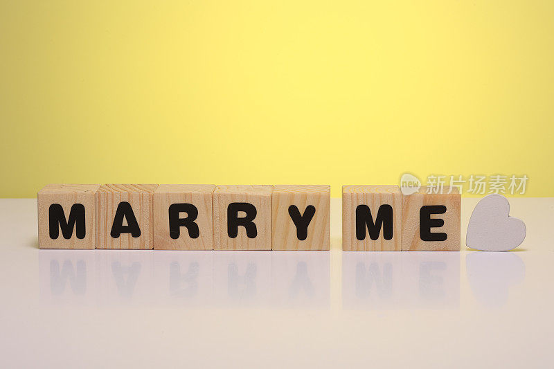 “嫁给我”字由木制立方体在黄色的背景