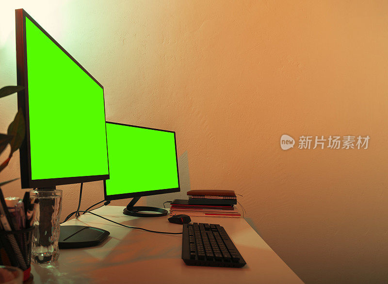 白色的桌子上有两个显示器绿色的屏幕打开了复印空间。