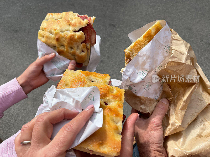 食物和饮料。意大利菜。吃佛卡夏面包，多只手拿着食物。