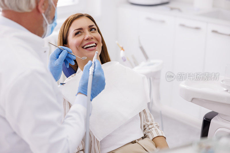 牙医用牙钻为病人固定牙齿