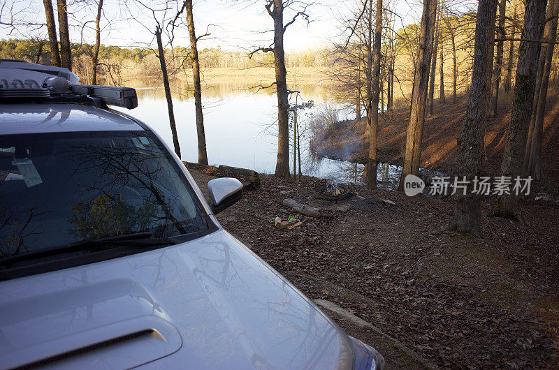 车辆停在平静的湖边营地