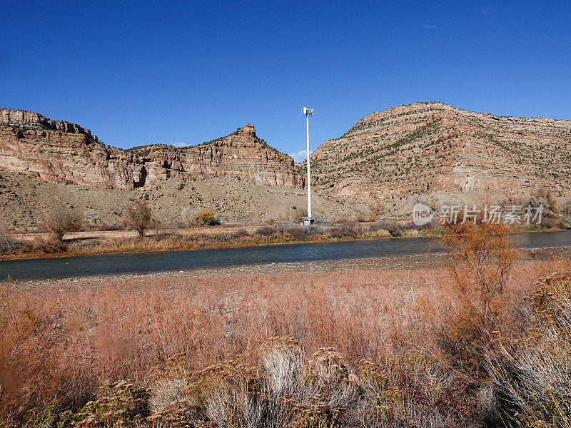 秋天，科罗拉多河岸边的高高的手机天线塔，与科罗拉多大Junction附近陡峭的峡谷壁相映成趣。