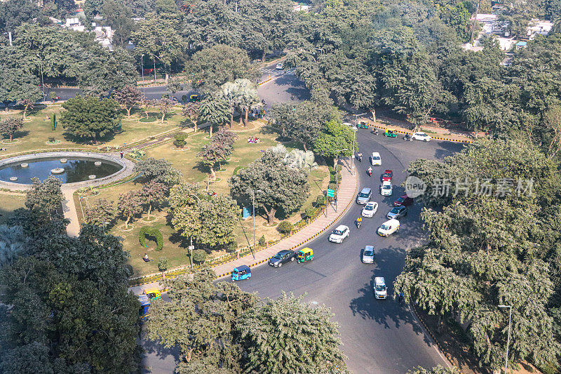 德里环形路口的交通图像，摩托车，汽车，主要道路上的汽车行驶，高架视图，重点关注前景