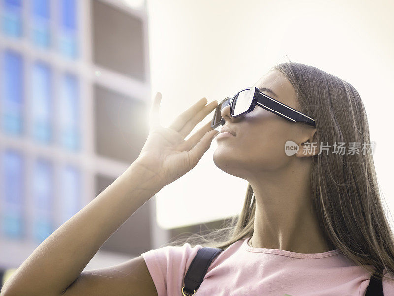 年轻女子拿着她的太阳镜在户外
