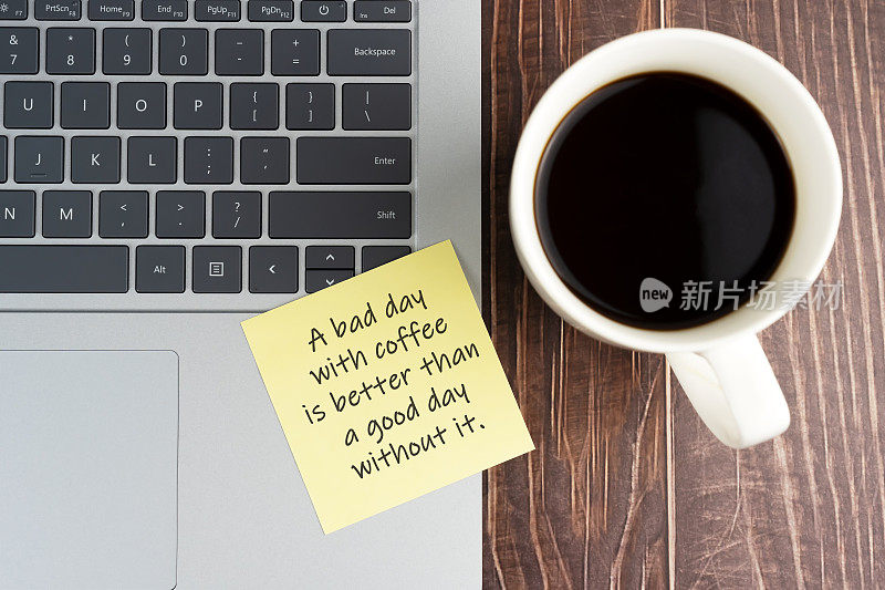 笔记本电脑和咖啡杯便签，上面写着文字——有咖啡的糟糕一天比没有咖啡的好一天。