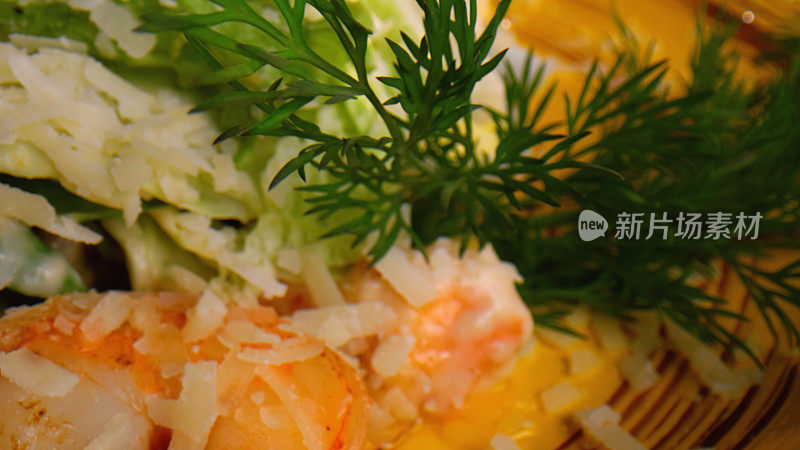 凯撒沙拉的特写，盘子里有虾，莳萝和奶酪