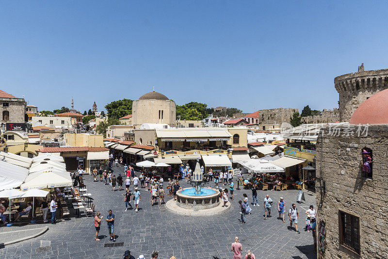 游客们在希腊历史悠久的罗德老城欣赏希波克拉底广场