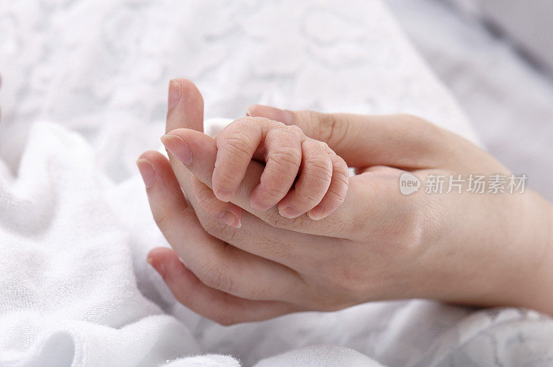 亚洲华人母亲和新生婴儿的手