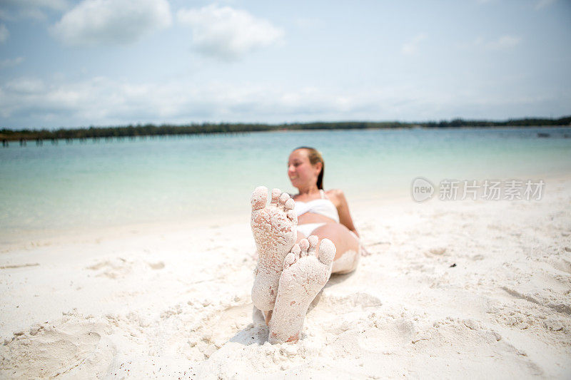 年轻女子在热带海滩上晒太阳