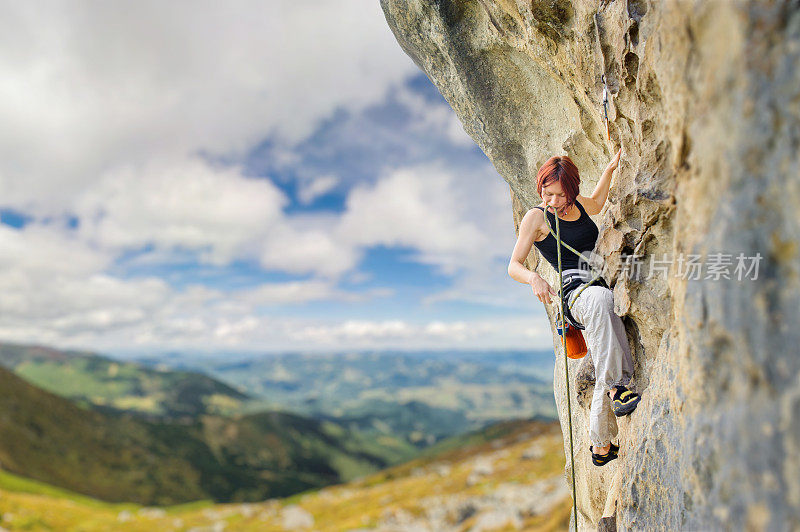 在陡峭的悬岩悬崖上的女性攀岩者