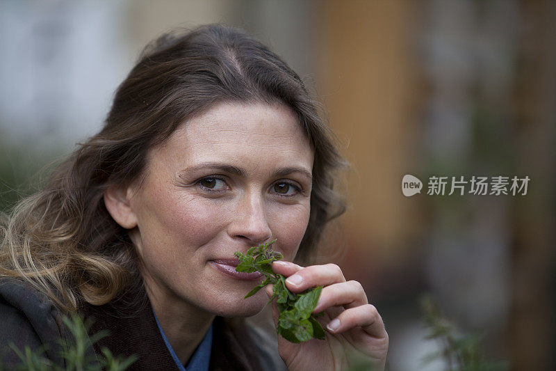 漂亮的年轻女人闻着薄荷味