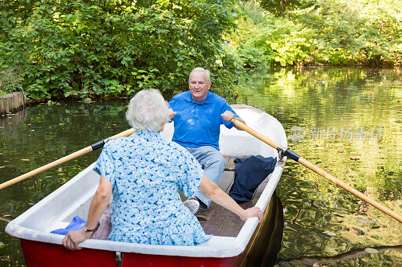 一对快乐的老夫妇在湖上划船