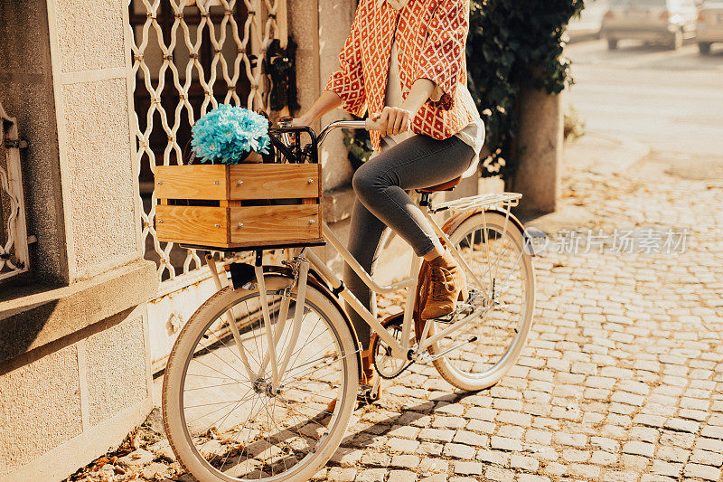 妇女骑着老式自行车在铺路石上