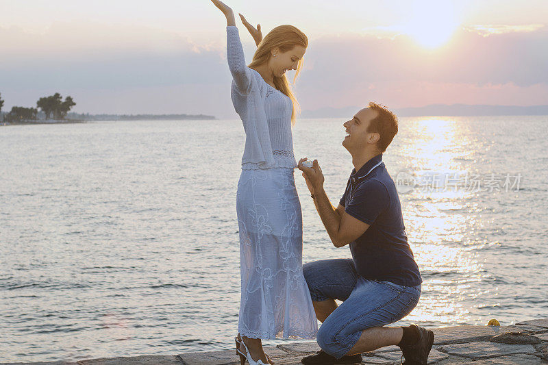 一个年轻人在海滩上向女朋友求婚