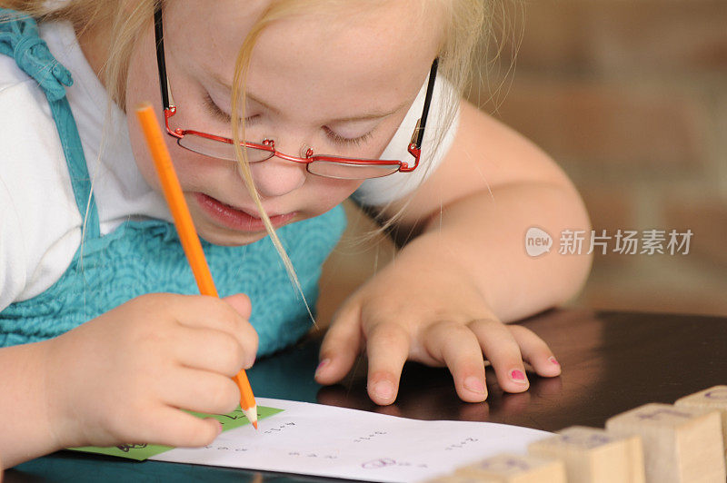 一个患有唐氏综合症的小女孩在纸上写字