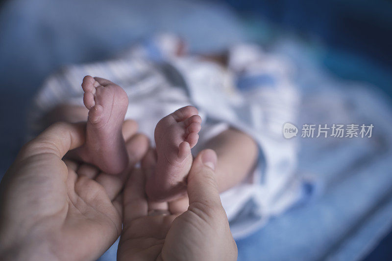 妈妈双手抱着宝宝的脚特写，温柔的时刻
