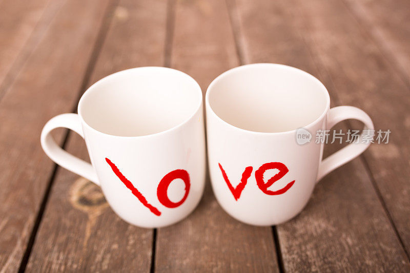 爱的文字在咖啡杯与木制背景。