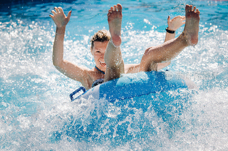 一对有趣的夫妇在一个浮子上玩水上飞车，溅起水花。暑假的概念。
