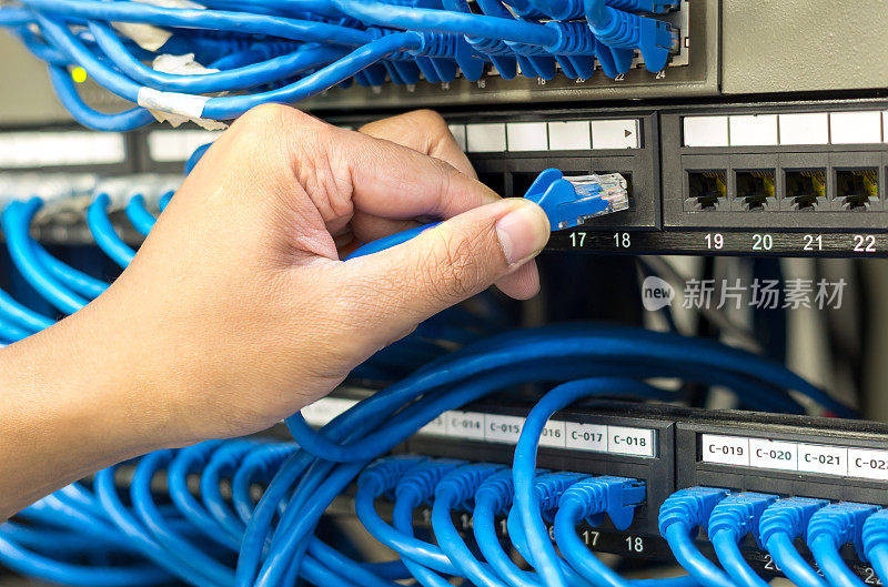 在服务器室，握住并插入网线连接到路由器和交换机集线器
