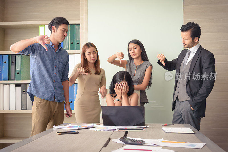 愤怒的团队同事在会议办公室责备沮丧的女商人