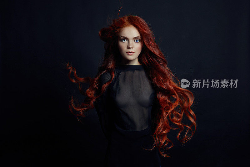 肖像红发性感女人的长发在黑色的背景。完美的女孩，蓝眼睛，干净的皮肤，美丽的妆容，红头发
