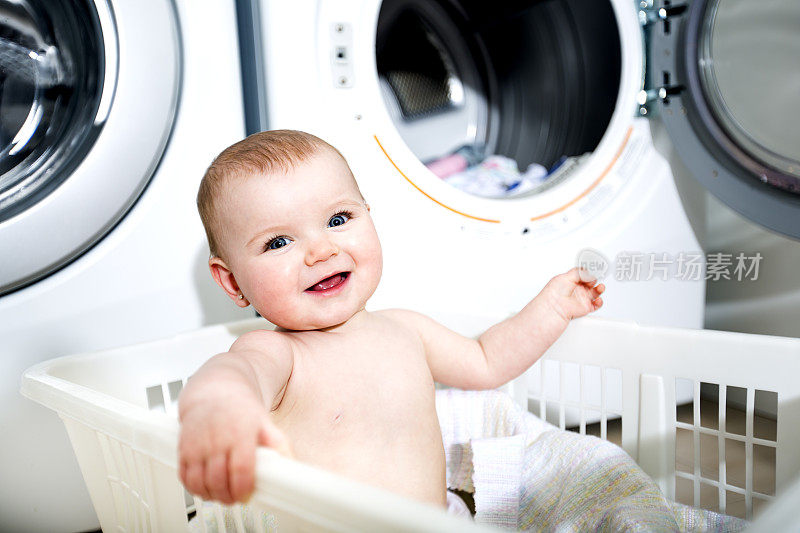 一个可爱的婴儿坐在洗衣篮里的肖像