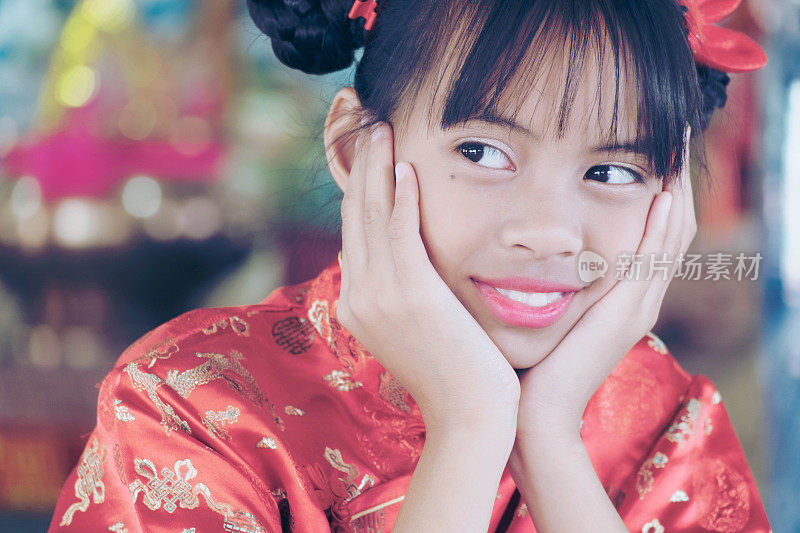 2018年中国新年快乐，亚洲女孩穿着中式服装向上帝致敬。农历新年或春节是中国最重要的传统节日。