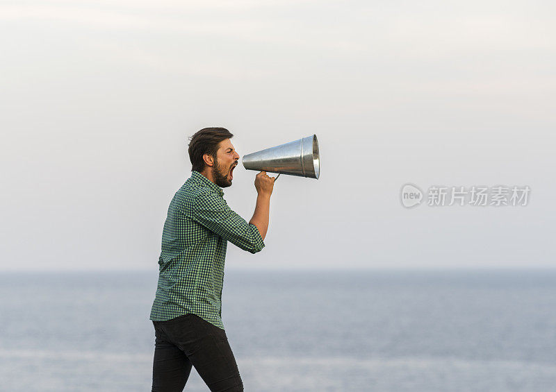 一个男人在室外通过扩音器大喊大叫