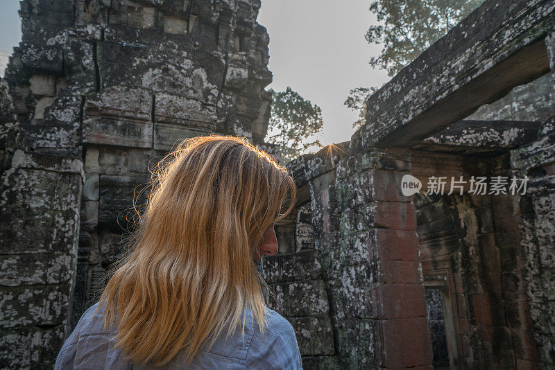 女游客漫游在古老的寺庙日落享受发现和旅游在亚洲，柬埔寨吴哥窟