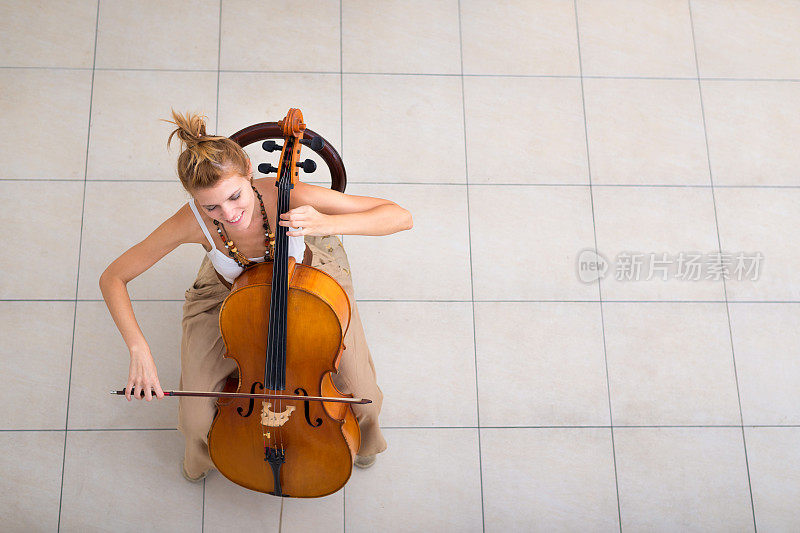 在舞台上演奏大提琴的年轻女音乐家
