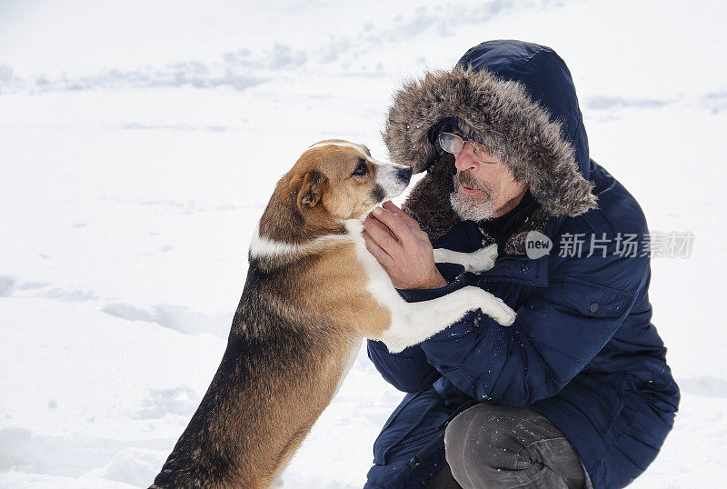 一个人在雪地上和狗玩