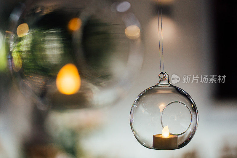 漂亮的挂蜡烛玻璃球，特写。现代婚礼装饰趋势。极简主义