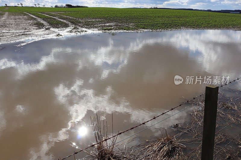 在乡村环境中，蓝天映衬着蓬松的白云，还有风力涡轮机或乡村公路