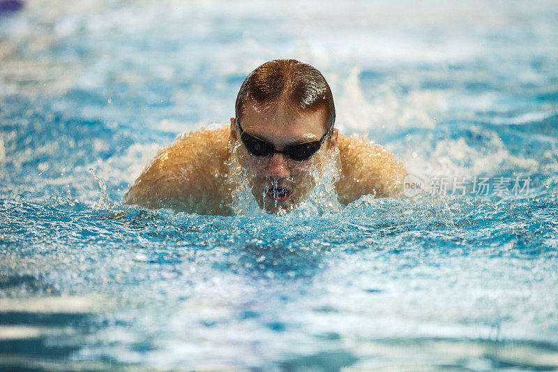游泳运动员在游泳池中练习蝶泳