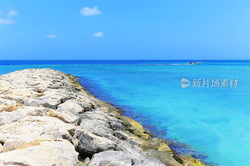 沉思:绿松石海滩与墩台和快艇-阿鲁巴，加勒比海