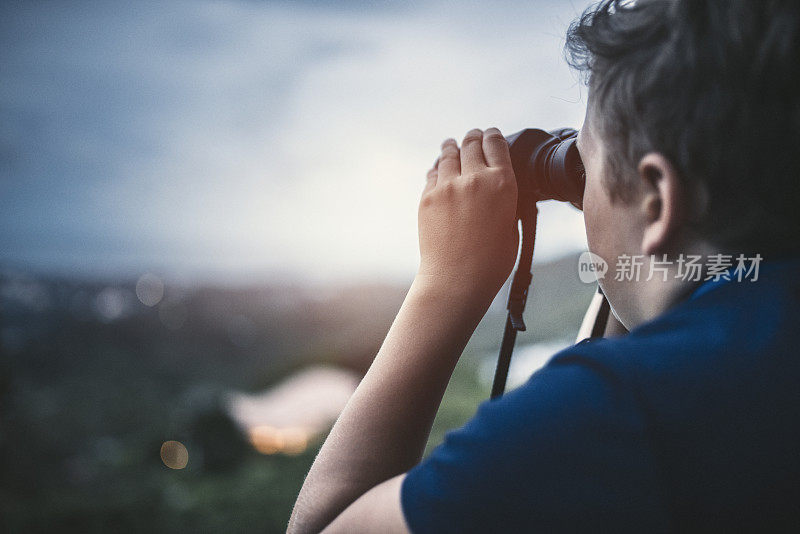 用望远镜看的少年