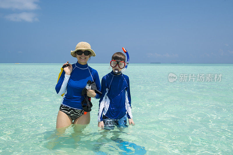 母亲和儿子有乐趣在浅水在小岛屿海滩四月，马尔代夫