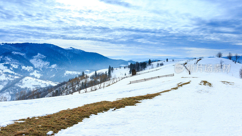 山峰上的雪被风吹走了。冬天的风景。天很冷，下着雪。