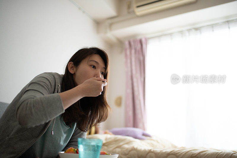 在房间里吃沙拉的女人