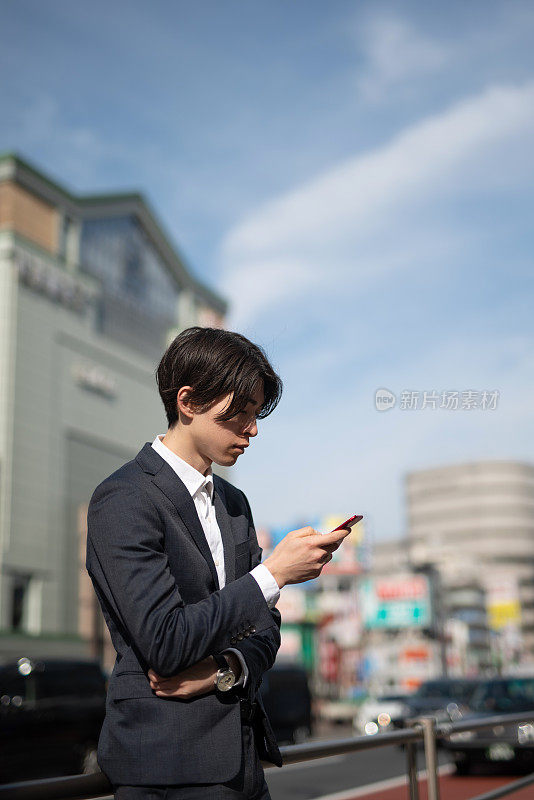 年轻商人在街上看智能手机
