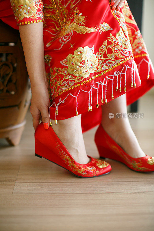 亚洲新娘身着传统服饰，穿着红色婚礼高跟鞋