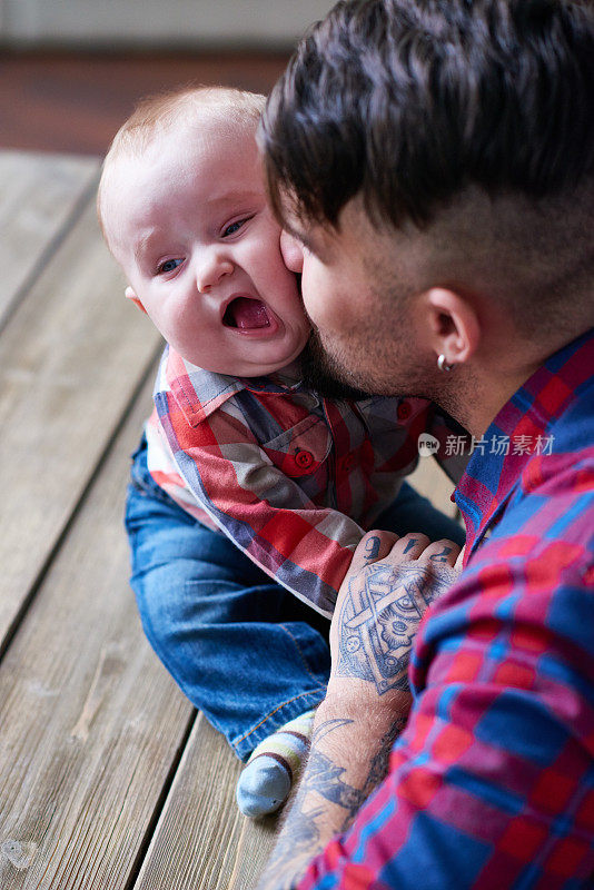 父亲亲吻可爱的婴儿的脸颊