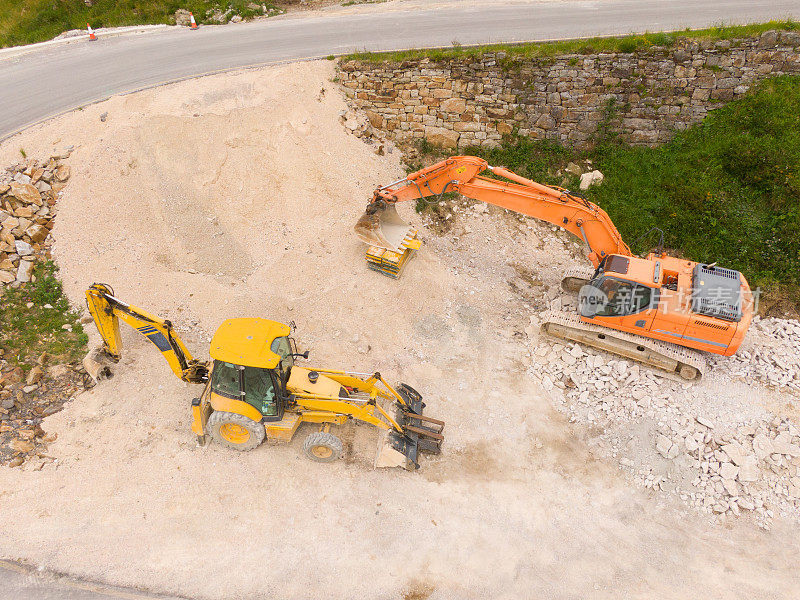 从上往下看，推土机和挖掘机正在道路工程区域铲土
