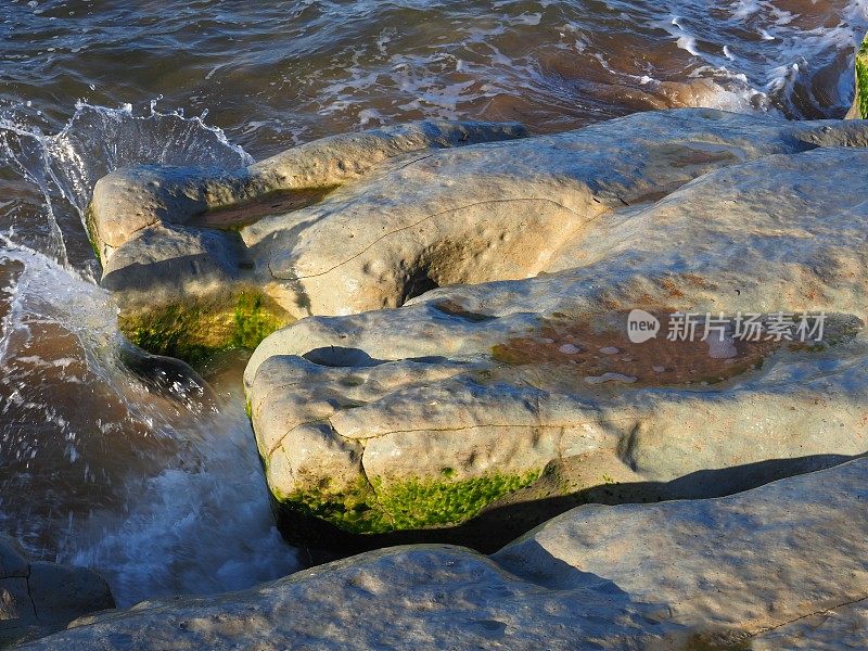水在多石的海滩上溅起水花