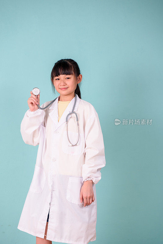 年轻的亚洲女孩穿着医生服